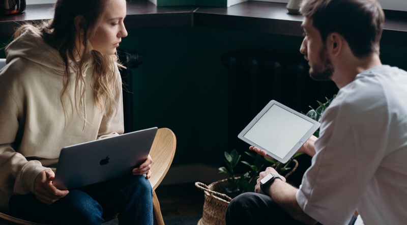 Two people reviewing a course on a laptop and tablet